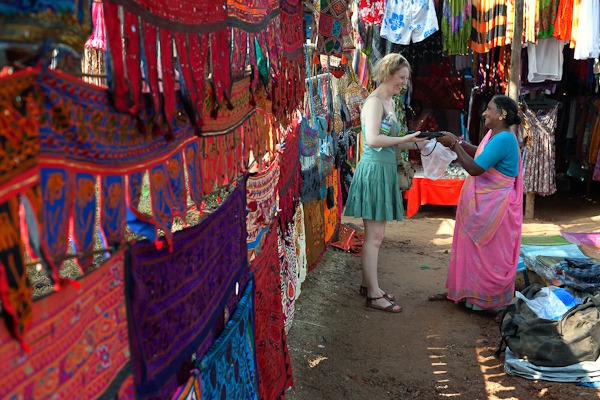 Western white lady bargaining with lady stall owner Anjuna Market Goa india