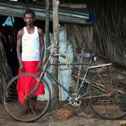 Man stood outside Shanti in Goa next to rusty old bike