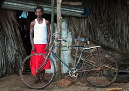 Man stood outside Shanti in Goa next to rusty old bike