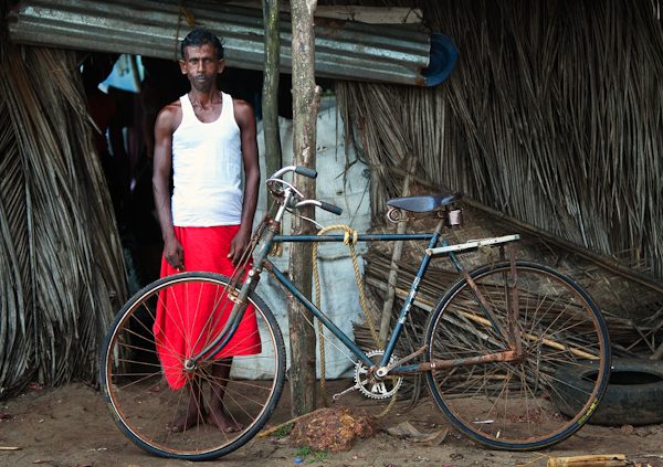 Man stood outside Shanti in Goa next to rusty old bike