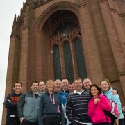 staff and managers from rowlands pharmacy stood in front of liverpool anglican cathedral before sponsored abseil NSPCC