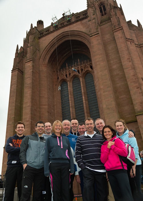 staff and managers from rowlands pharmacy stood in front of liverpool anglican cathedral before sponsored abseil NSPCC