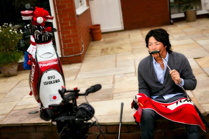 ryo ishikawa kisses his golf club next to his golf bag with his name on it