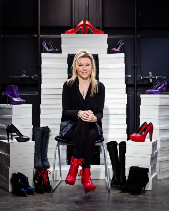 lady sat on chair surrounded by shoes on top of their shoe box