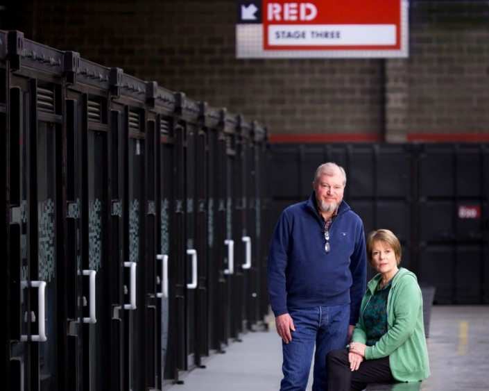 Hilary Bevan-Jones and Paul Frith photographed by the shipping containers at The Sharp Project