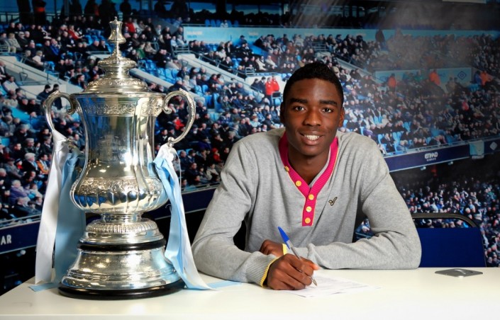 devante cole signs for man City wit FA Cup next to him