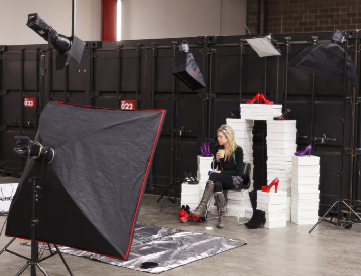 Behind the scenes on location shoot studio light, subject and black shipping containers all around