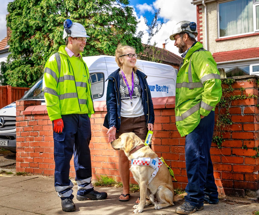 2 male construction works chat to girl with blind dog