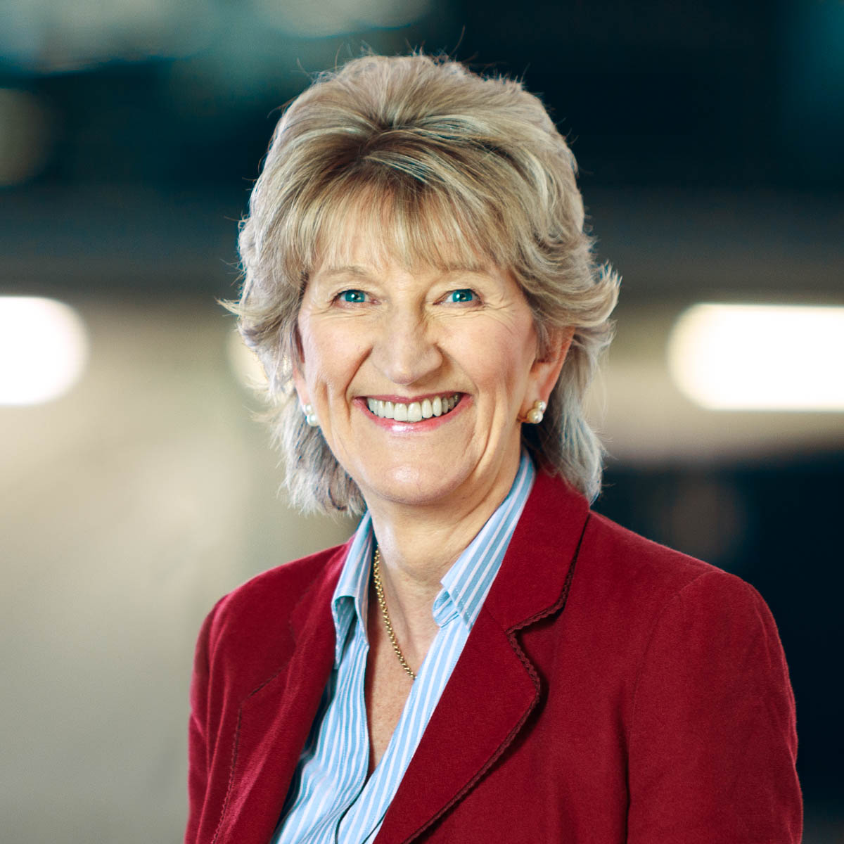 Mature business woman head and shoulders shot with office background